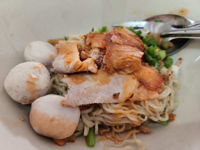 บะหมี่เหลืองแห้งกับหมูย่างชิ้นโตและลูกชิ้นหมู ต้นหอมข้างชาม