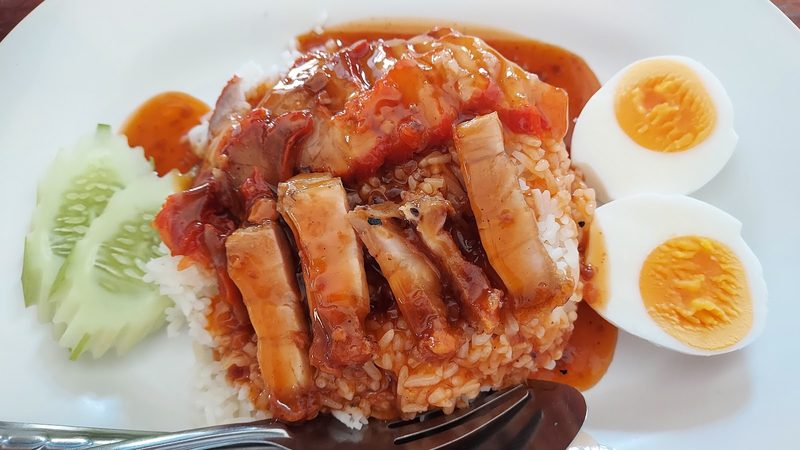 ข้าวหมูแดงหมูกรอบราดน้ำแดง ไข่ต้มผ่าครึ่งและแตงกวา