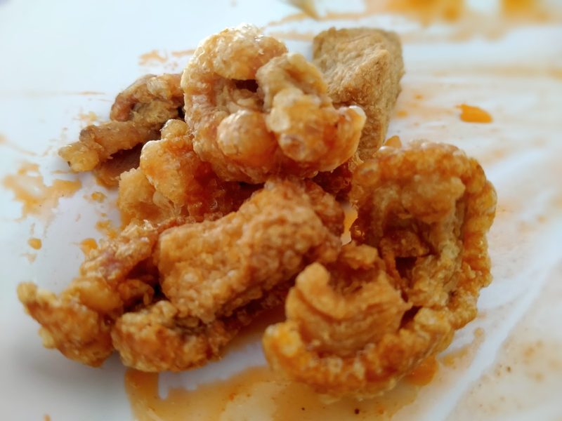 หมูกรอบทอดชิ้นพอดีคำบนจานขาว